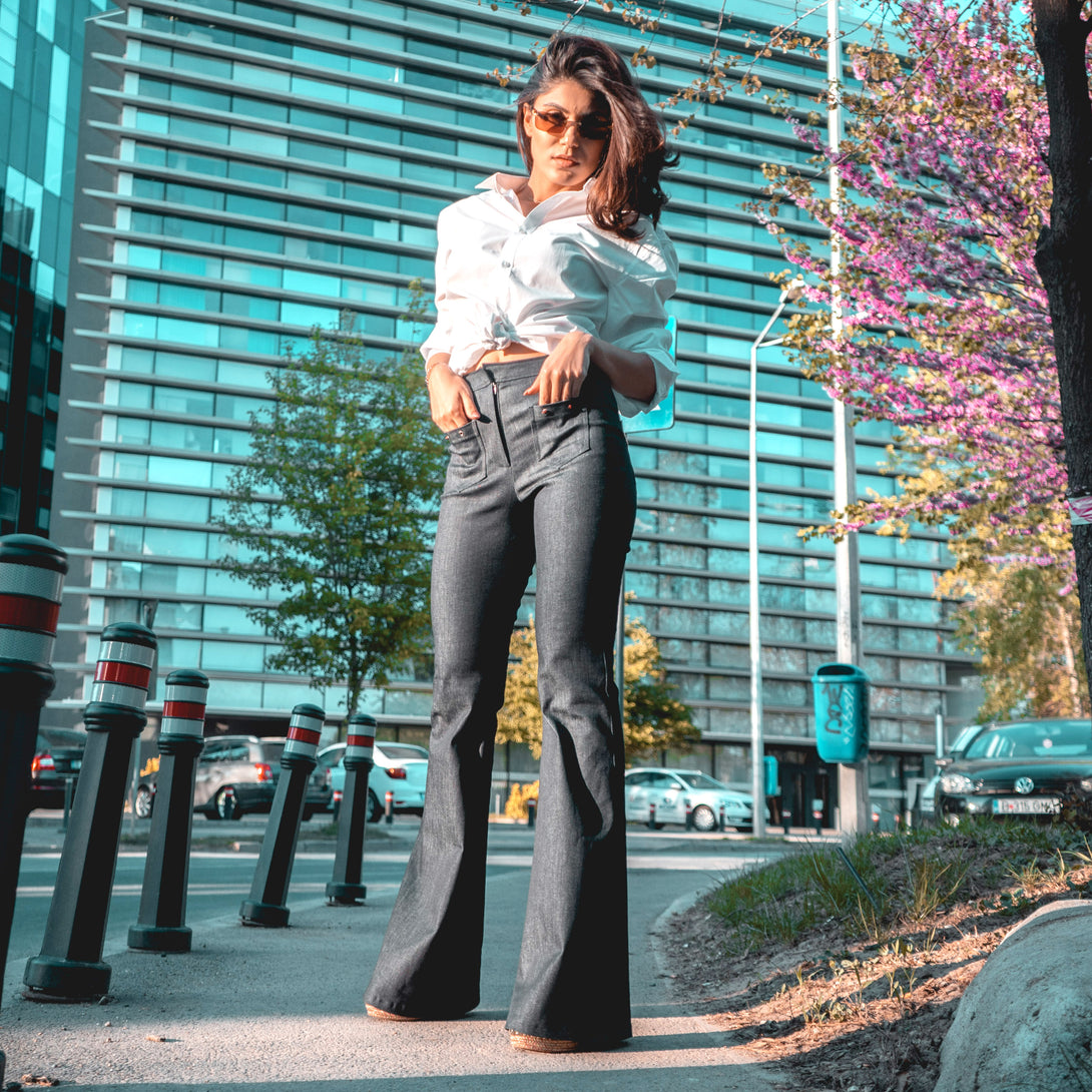 woman posing outdoor in a pair of jeans and shirt